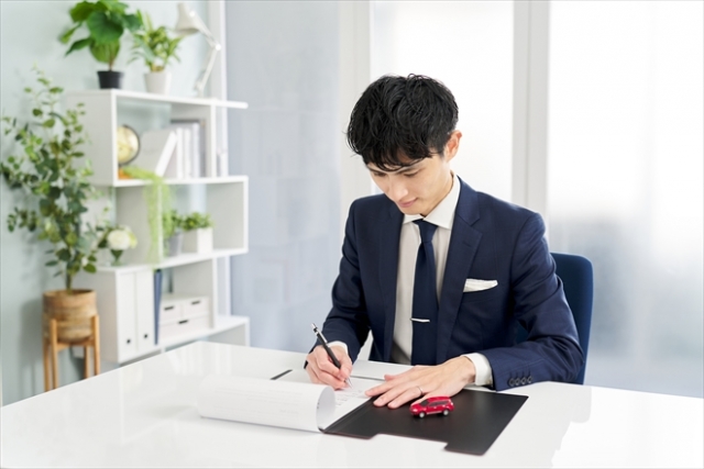 書類にサインをするビジネスパーソン